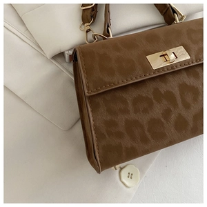 Detailaufnahme der Leoparden-Handtasche mit goldenem Drehverschluss und Samt-Textur