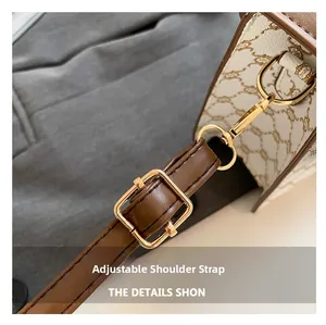 Detail of brown adjustable faux leather shoulder strap with gold-tone hardware and buckles
