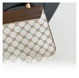 Macro shot of geometric pattern canvas and fine brown leather stitching on handbag