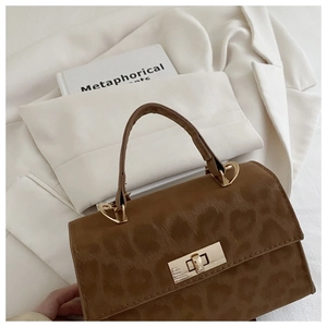 Nahaufnahme der Leoparden-Textur und des goldenen Drehverschlusses an der Handtasche