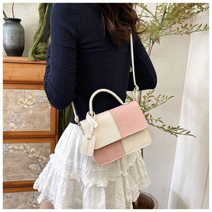 Close-up of pink and beige patchwork crossbody bag with elegant leather texture and handle