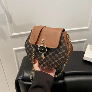 Sac bandoulière hexagonal avec rabat marron, motif monogramme et pendentif en forme de chat