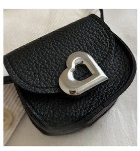 Close-up of black lychee grain leather mini bag with silver heart-shaped metal clasp