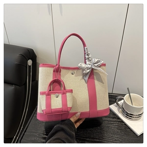 Detail of canvas tote bag with pink leather trim, decorative scarf and mini pouch