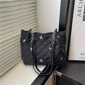 Fashionable black quilted tote bag with white bow embroidery and metal chain strap