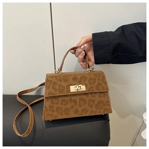 Details der Handtasche mit Leopardenmuster, goldenem Drehverschluss und Schultergurt