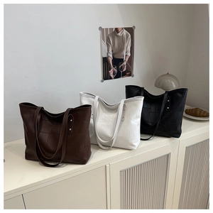 Detail showing high-capacity tote bags with geometric texture and rivet decorations