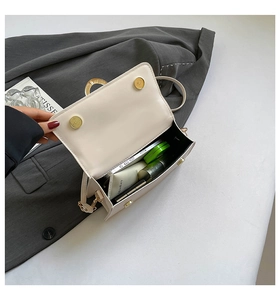 Top view of cream sequin crossbody bag showing interior storage for phone and cosmetics