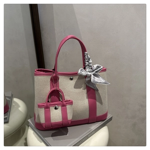 Detail of pink leather trim on canvas tote bag with mini pouch and floral silk scarf