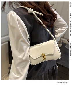 Detail of white leather shoulder bag with gold metal twist lock and knotted strap