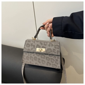 Detailansicht der grauen Tasche mit Leopardenmuster, Goldschloss und matter Texturierung