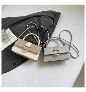 Detail of chic shoulder bags with glitter flaps and gold D-shaped metal buckles