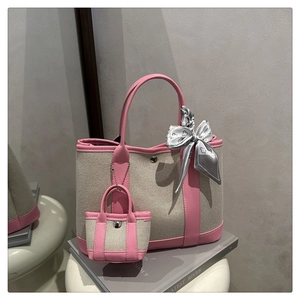 Detail of canvas tote bag with pink leather trim, mini pouch charm and floral silk scarf