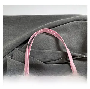 Détail des poignées en cuir rose et du motif en damier sur le sac cabas