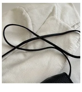 Detail of soft black lychee texture leather shoulder strap for mini saddle bag