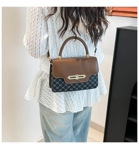 Detail of vintage tote bag with leather flap and logo pattern shown on a model