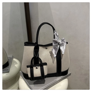 Canvas tote bag with black leather trim, silk scarf detail and mini pouch on display