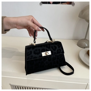 Detail der Handtasche mit Leopardenmuster und goldenem Drehverschluss vor Innenhintergrund