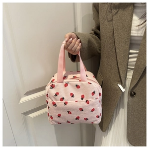 Detailed close-up of pink corduroy lunch bag featuring cute strawberry print and zipper