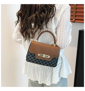 On-body shot of a vintage patchwork shoulder bag with leather handle and metal clasp