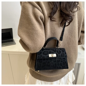 Detail of vintage leopard print crossbody bag with gold hardware shown on a model