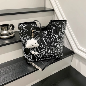 Borsa tote nera con stampa graffiti, tracolla e ciondolo a nuvola su scale studio