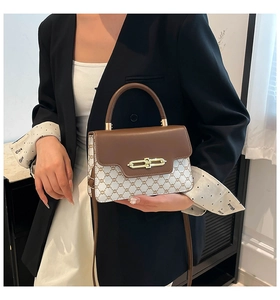 Detail of vintage crossbody bag showing luxury monogram pattern and gold metal buckle