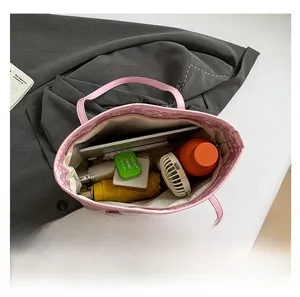 Vue intérieure montrant la grande capacité de rangement du sac fourre-tout rose pour PC