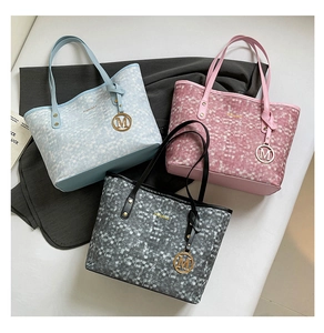 Detailed shot of stylish tote bags in blue, pink, and grey with geometric textures