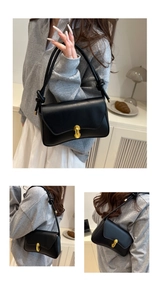 Detail of black leather shoulder bag featuring a gold horseshoe buckle and strap knots
