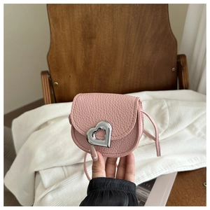 Détail du sac à main en cuir rose avec grain litchi et fermoir en forme de cœur