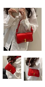 Detail of red glossy shoulder bag with golden horseshoe clasp and knot strap
