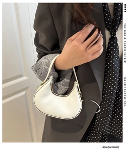 Detail of white hobo bag with sleek synthetic leather and gold metallic zipper hardware