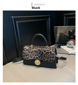 Detail der Vintage-Umhängetasche mit Leopardenmuster und goldenem Drehverschluss im Lifestyle