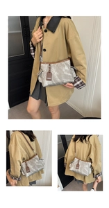 Détail du sac bandoulière rétro gris avec garniture en cuir brun et poches latérales
