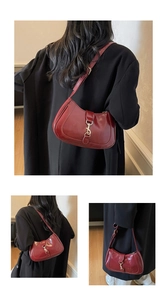 Detail view of burgundy moon bag with glossy finish and adjustable gold buckle strap