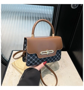 Detail of vintage tote bag featuring brown leather flap and monogram pattern texture