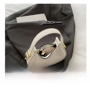 Detail view of crescent bag interior showing capacity for cosmetics and gold hardware