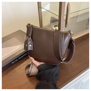 Détail du sac Hobo marron foncé avec bandoulière tissée et détails en métal doré