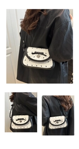 Détail du sac bandoulière contrasté avec imprimé lapin, nœud en soie et pendentif cœur