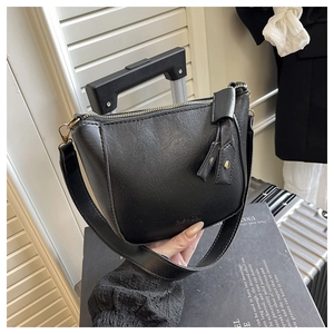 Close-up of black leather texture and fashion lettering on the minimalist underarm bag