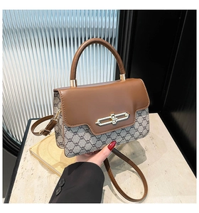 Detail of vintage crossbody bag with gold chain buckle and monogram patchwork pattern