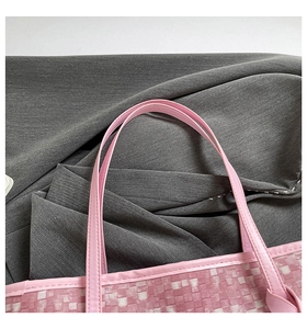 Detailed close-up of pink woven texture tote bag showing durable shoulder strap attachment