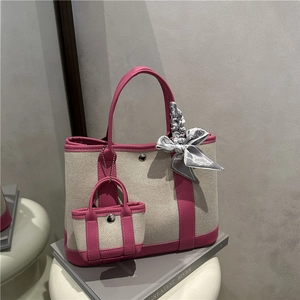 Canvas tote bag with rose red leather trim and printed silk scarf on white stool