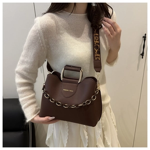 Dettaglio borsa in pelle marrone caffè con catena dorata e ampia tracolla stampata