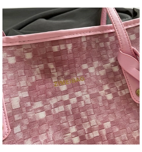 Detail of pink and white woven tote bag with leather piping and ZIMEIBAG logo