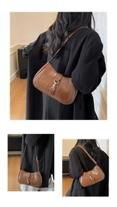 Detail of vintage brown hobo bag featuring polished leather and iconic metal piston lock