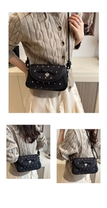 Détail du sac à nœud noir avec tissu texturé et pendentif en métal en forme de cœur