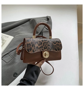 Détail d'un sac à main vintage marron avec rabat léopard et fermoir rotatif doré élégant