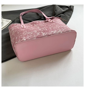 Detailed view of pink checkered woven tote bag with smooth leather handles and base